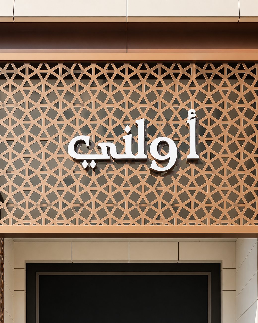 Awani Arabic signage detail against bronze geometric pattern wall, Dubai Hills Mall