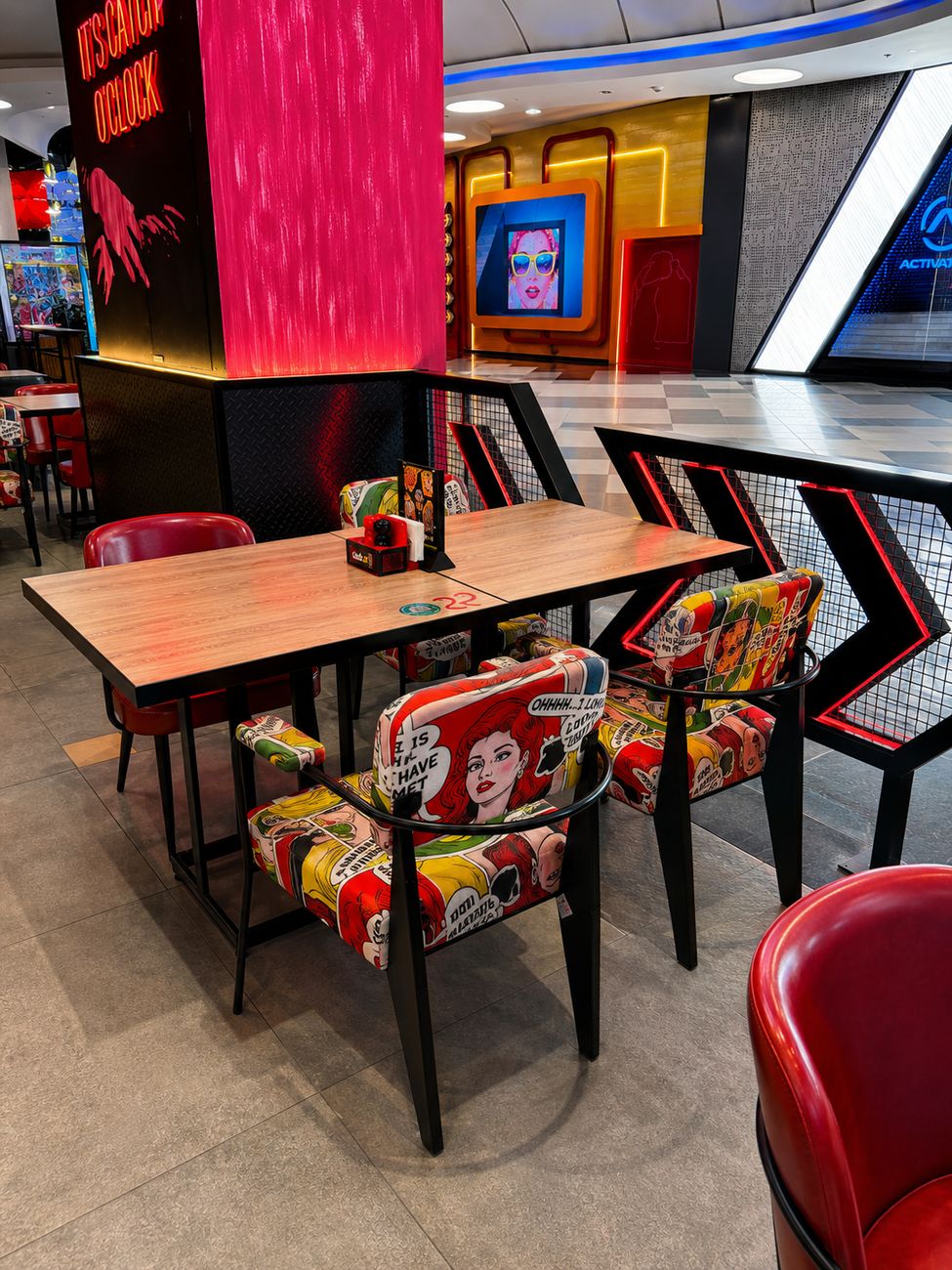 Catch 22 booth seating with comic book chairs and mall view, Mirdiff City Centre