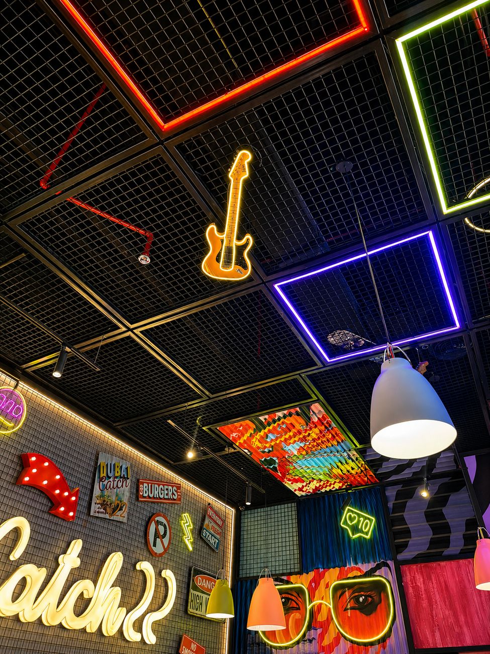 Catch 22 neon ceiling detail with guitar and signage wall, Mirdiff City Centre