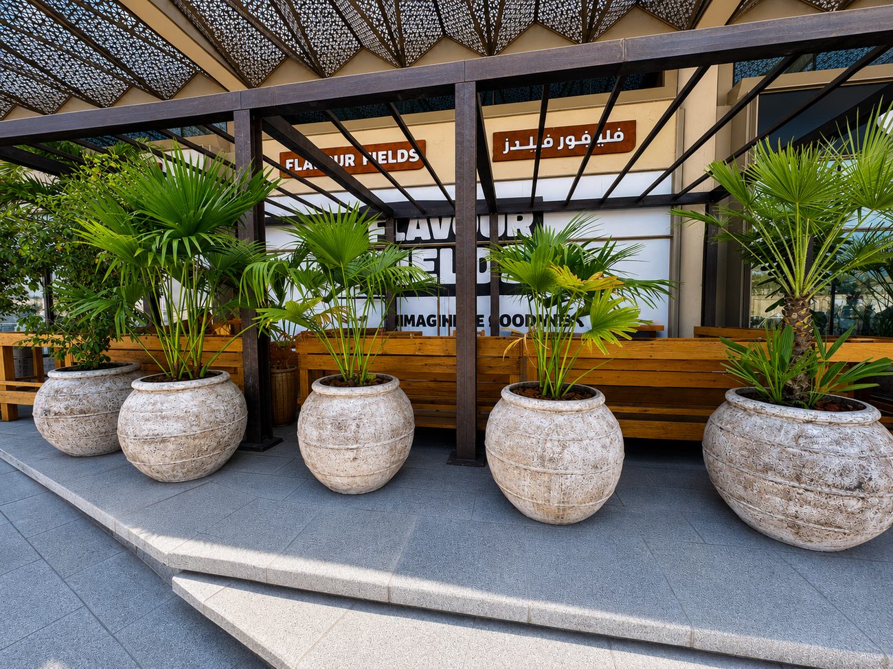 Potted palms beneath the entrance canopy at Flavour Fields, Dubai Galleria Mall, Jumeirah