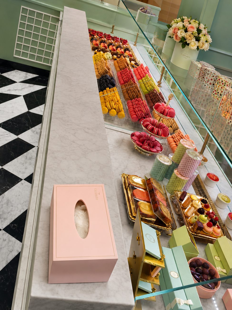 Laduree counter display detail with macarons and pastries, overhead view, The Dubai Mall