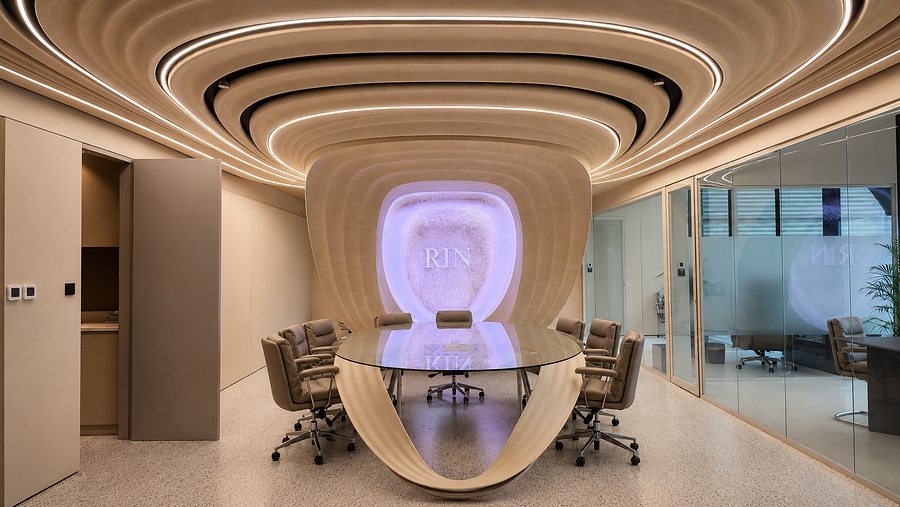 RIN Foundation boardroom with purple ambient lighting, bespoke glass table and sculpted joinery, Dubai