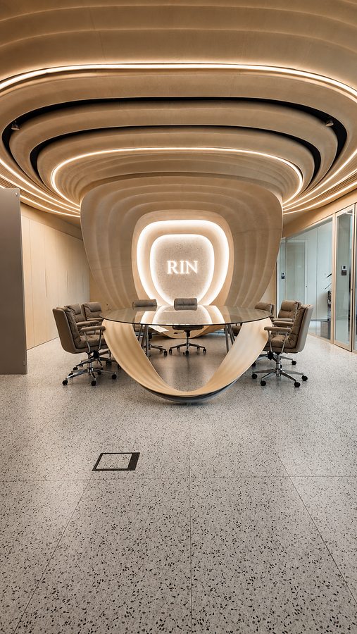 RIN Foundation boardroom portrait view, concentric ceiling waves framing illuminated RIN logo, Dubai