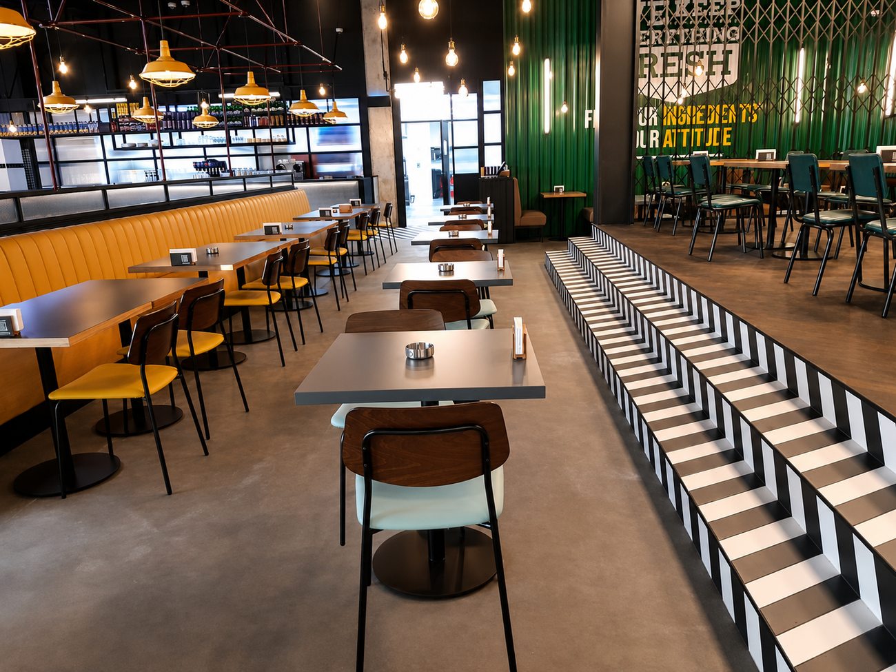Roadster Diner dining area with striped runway steps and green feature wall, Mirdiff City Centre